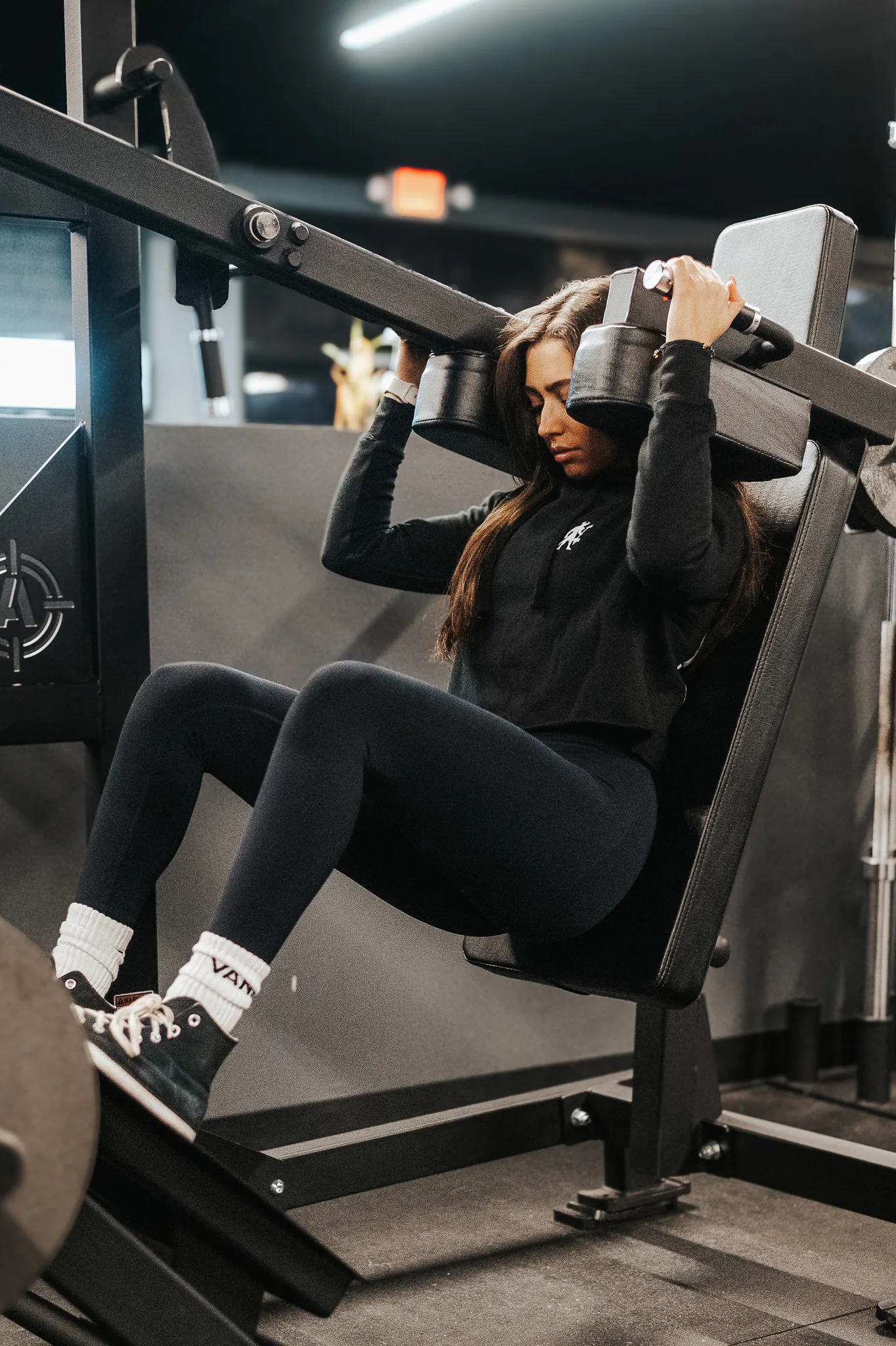 A member training on a plate-loaded Arsenal machine on the main floor at Athlos Iron Lair