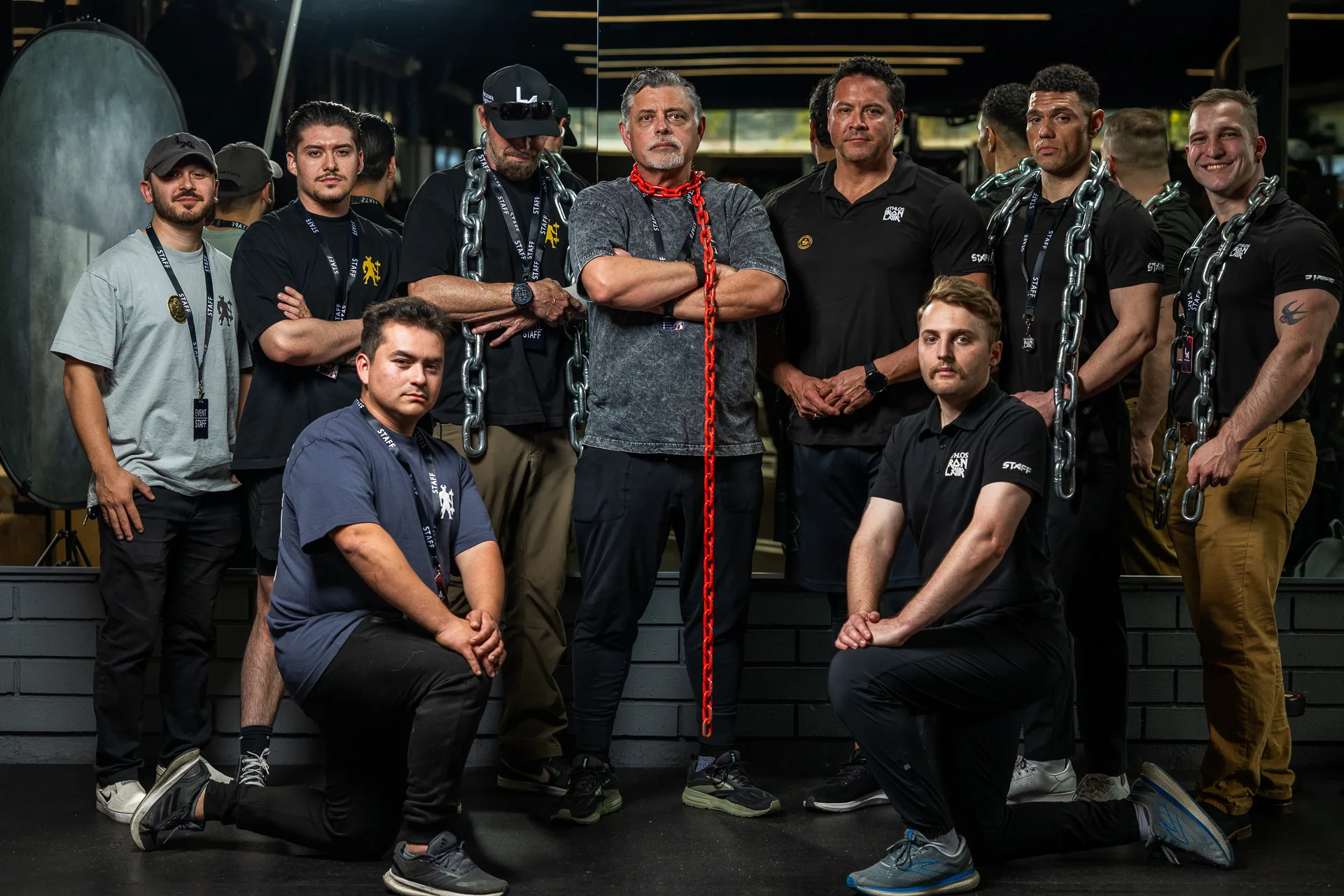 The Athlos Iron Lair team lined up in front of the rack wall, arms folded.