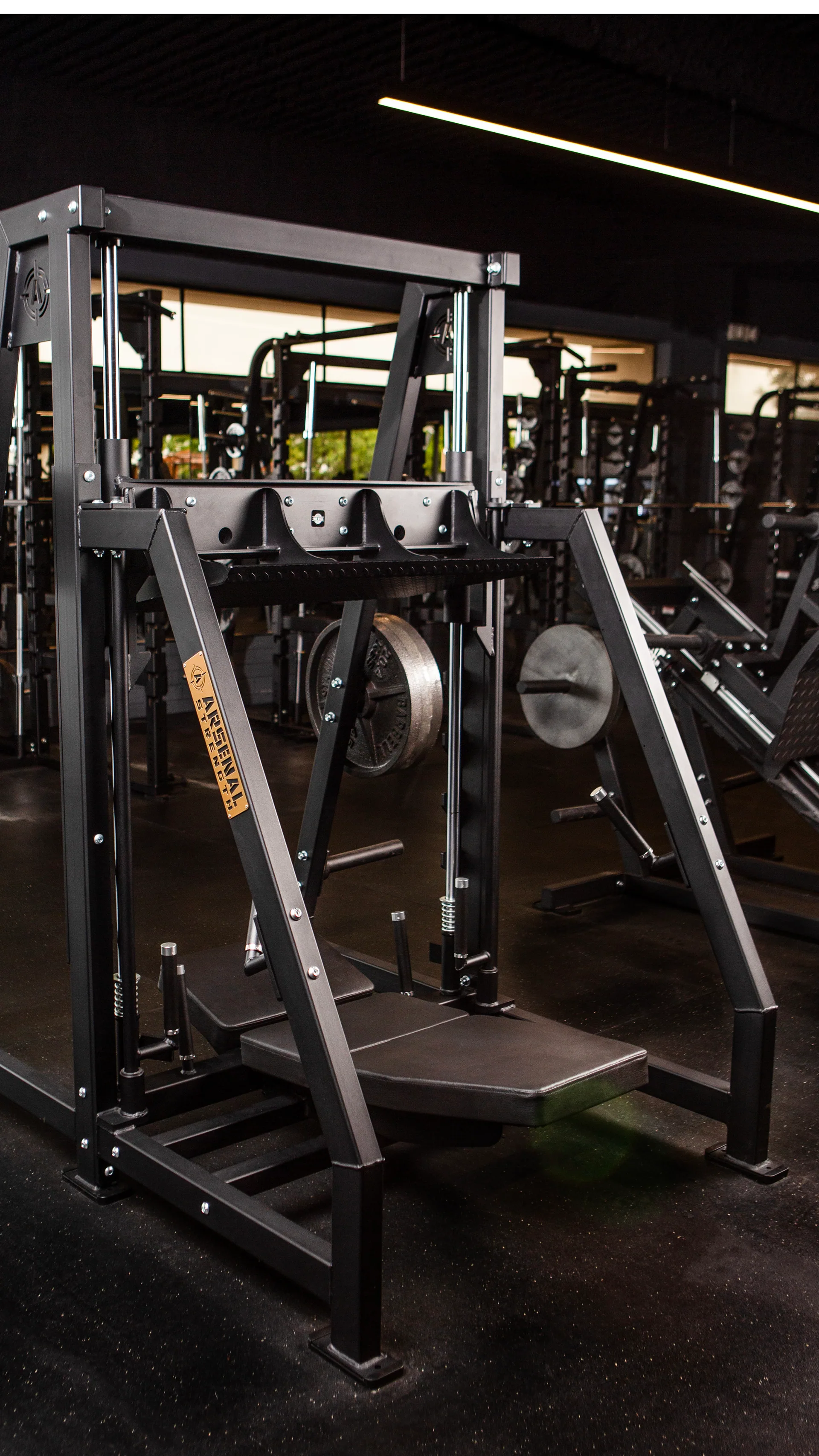 The Arsenal vertical leg press, a tall steel frame with the back pad on the floor and the sled running up the uprights.