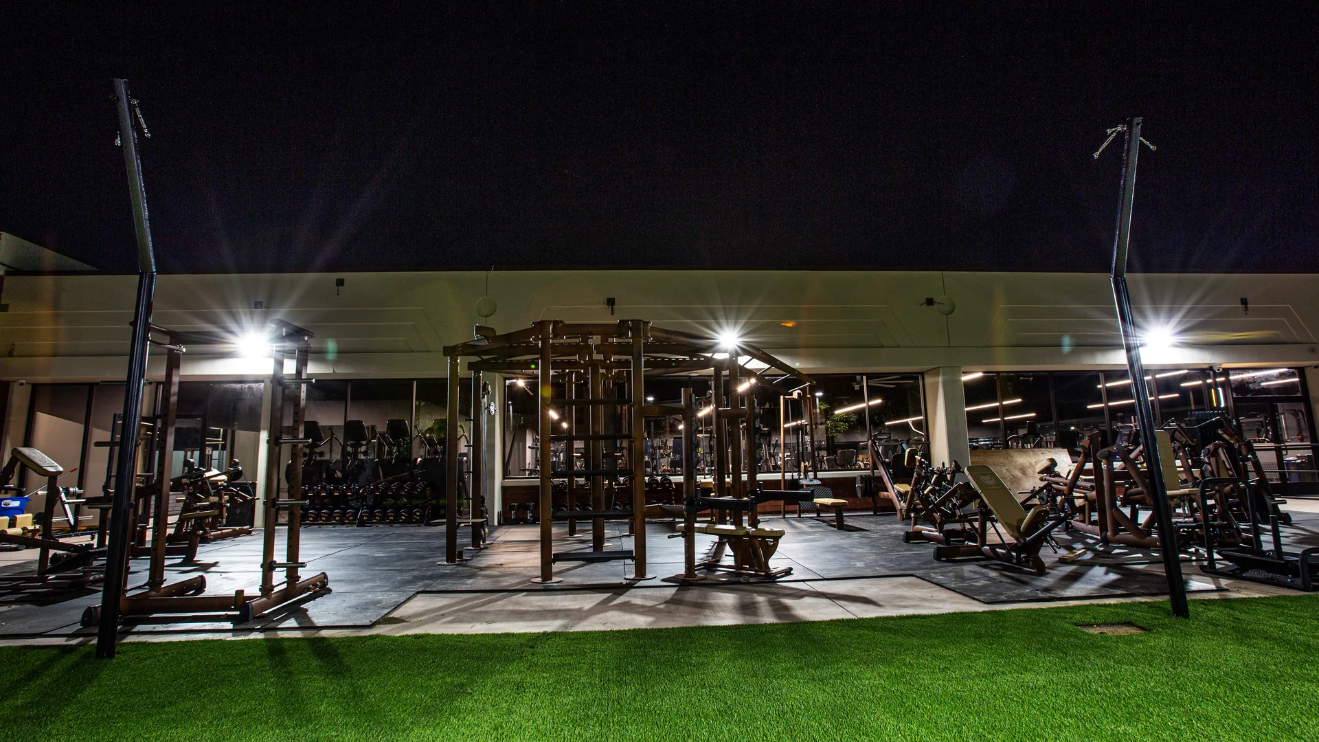 Wide view of the outdoor turf training area lit at night