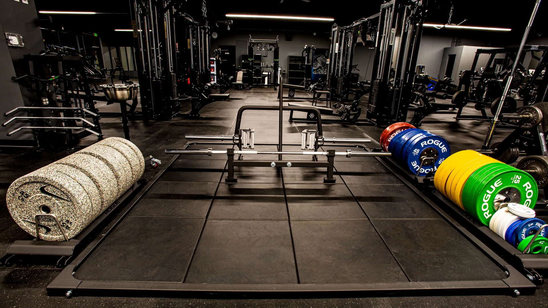 Deadlift platform with a loaded barbell and stacked coloured bumper plates