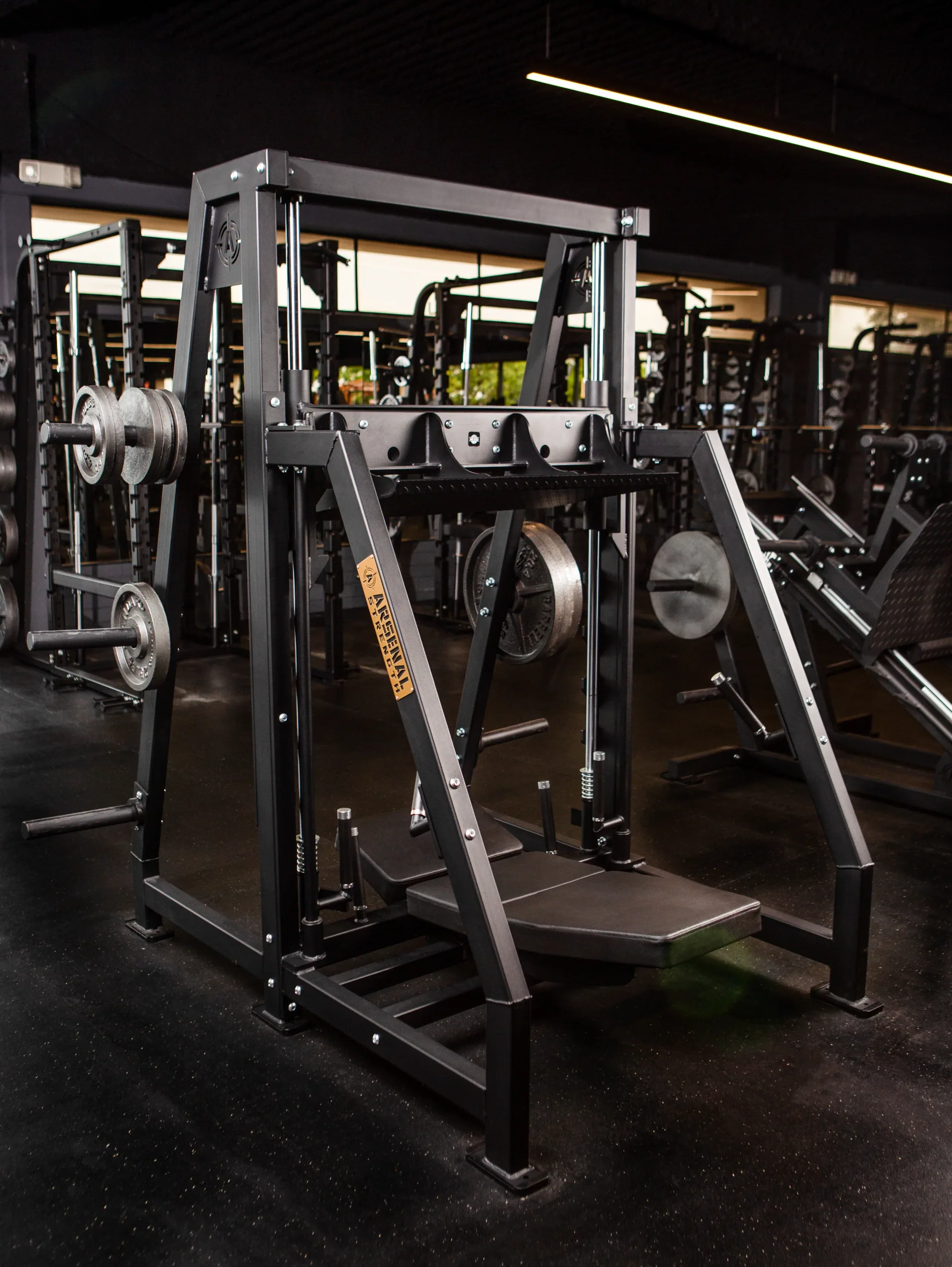 A new plate-loaded Arsenal machine on the training floor, weight plates racked either side